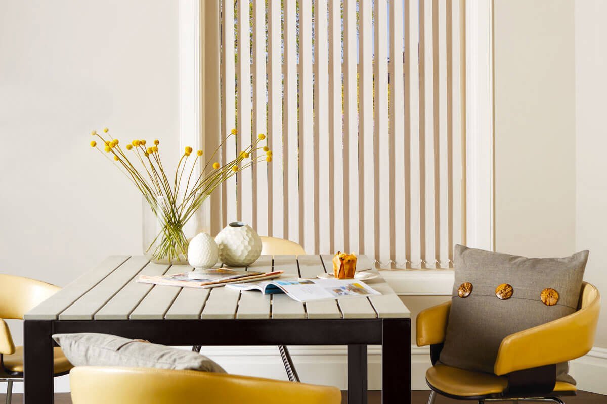 White vertical window blinds in modern lounge area.