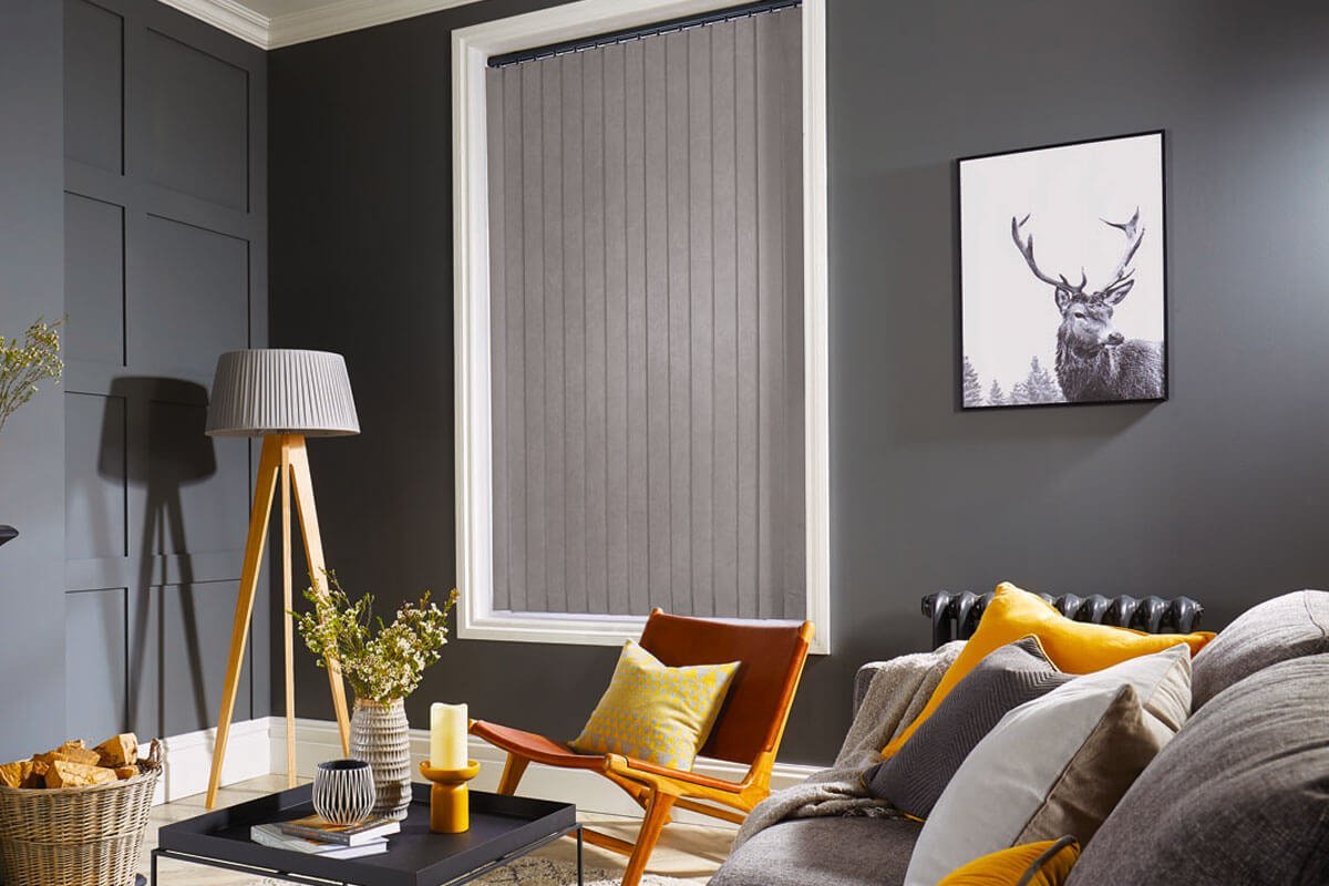 Grey vertical blinds in large window with grey and yellow modern furniture.