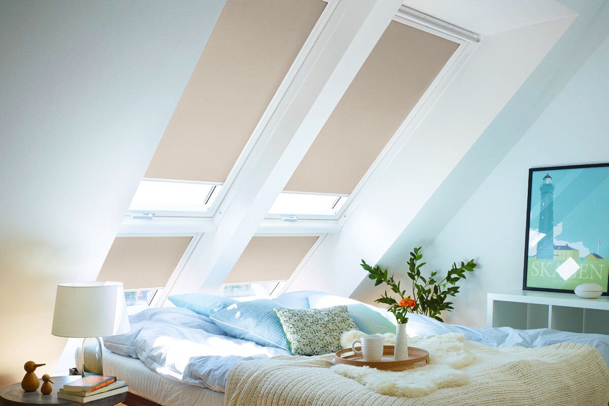 Beige skylight blinds in skylight windows of modern bedroom area.