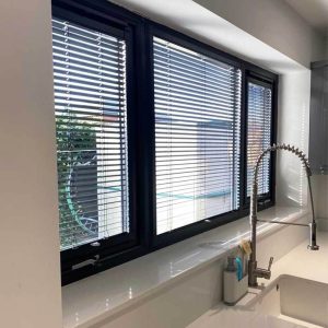 Perfect-fit kitchen blinds with dark frame windows.