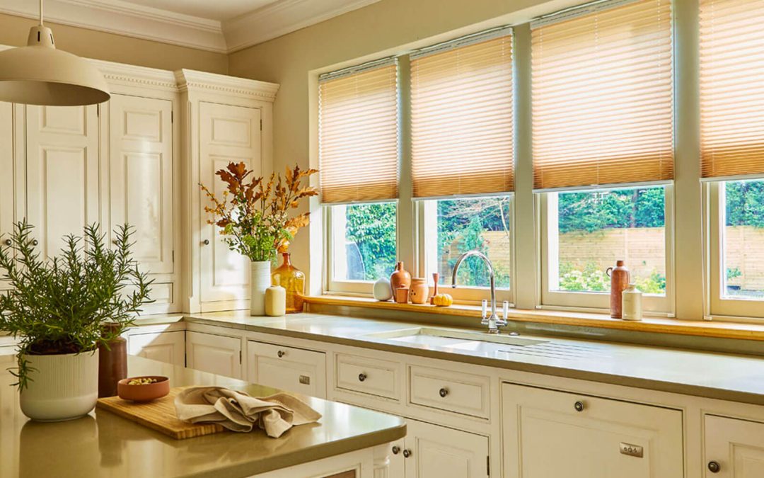 Pleated window blinds half open showing outdoor garden area in farmhouse style kitchen.