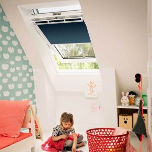 Skylight blinds in modern child's bedroom with child playing on the carpet. Velux Blinds