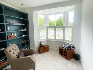White, wooden shutter blinds in modern lounge area.