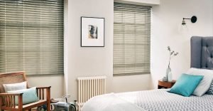 Grey, metal venetian blind in modern bedroom with modern furniture.